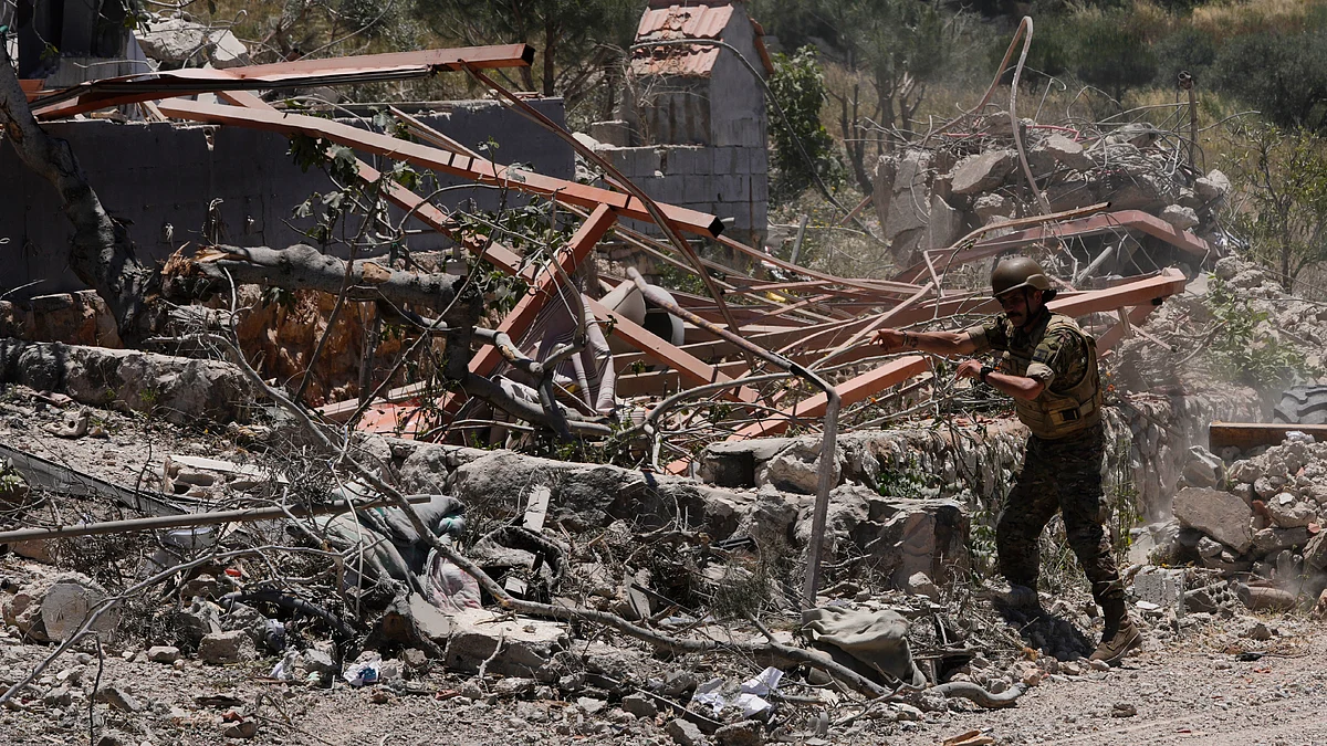 A Lebanese soldier removes rubble from clashes between Hezbollah and Israeli fighters
