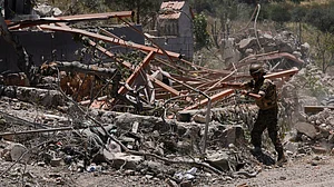 A Lebanese soldier removes rubble from clashes between Hezbollah and Israeli fighters