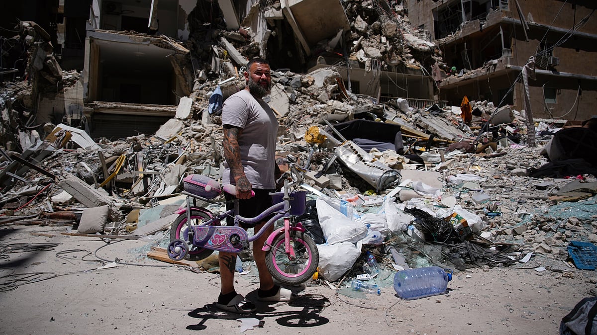 A man searches for belongings in the rubble after an Israeli strike, 19 June