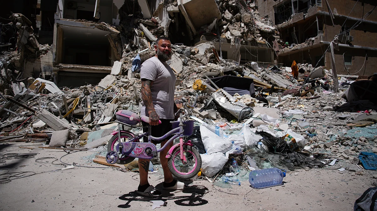 A man searches for belongings in the rubble after an Israeli strike, 19 June