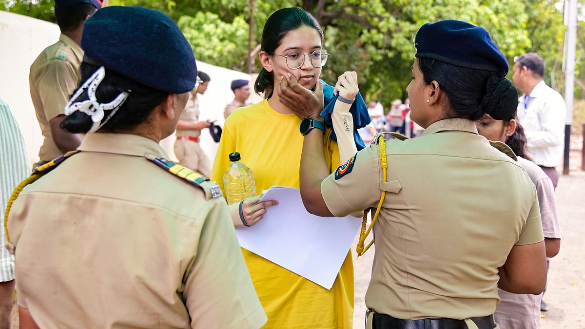 A candidate undergoes a security check at an exam centre in Nagpur, 21 June