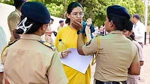 A candidate undergoes a security check at an exam centre in Nagpur, 21 June