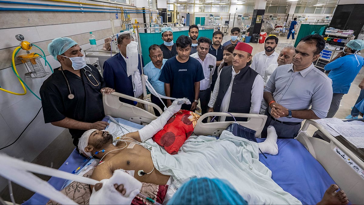 Akhilesh Yadav interacts with a person injured in the fire at a commercial building in Aliganj