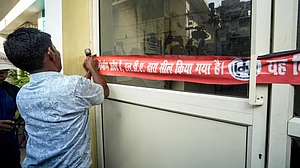 An administration official seals Allen Coaching in Hazratganj area.