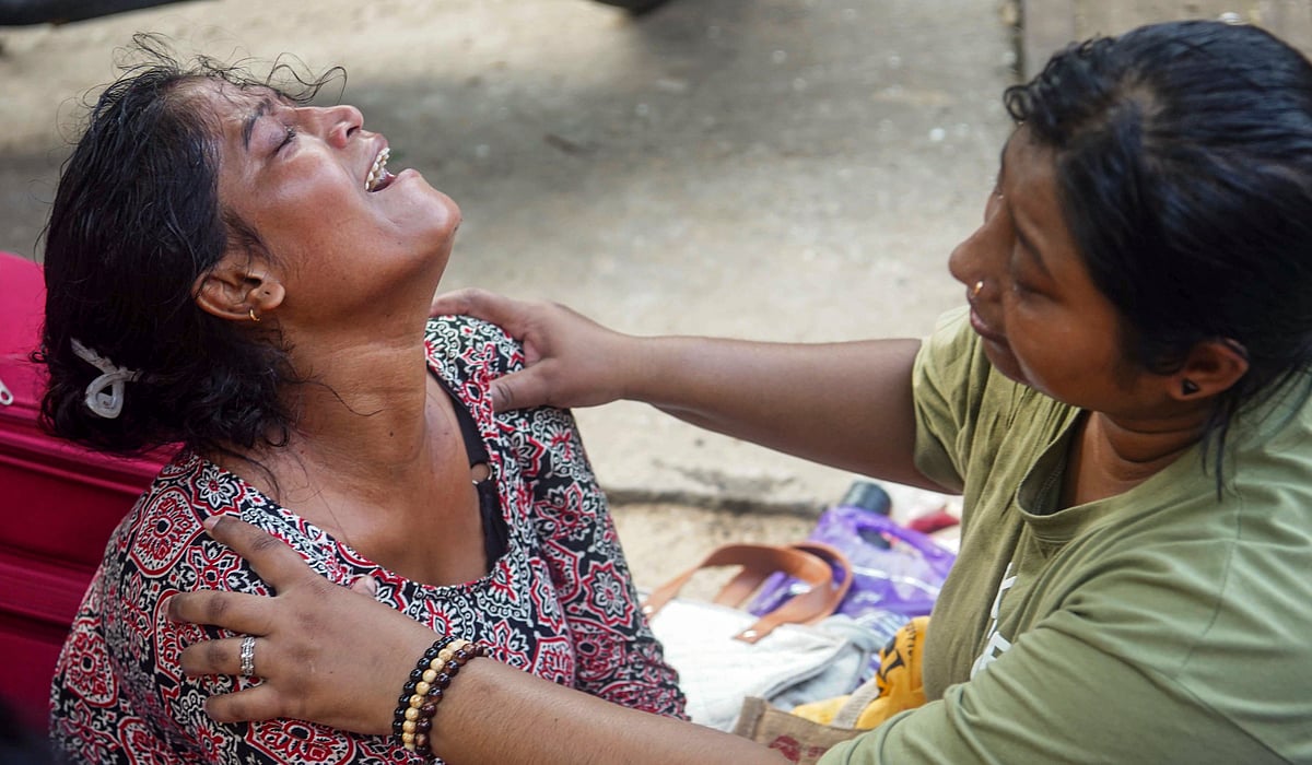 Wife of Suman Karmakar, left, mourns, after he died in the under-construction warehouse collapse. 