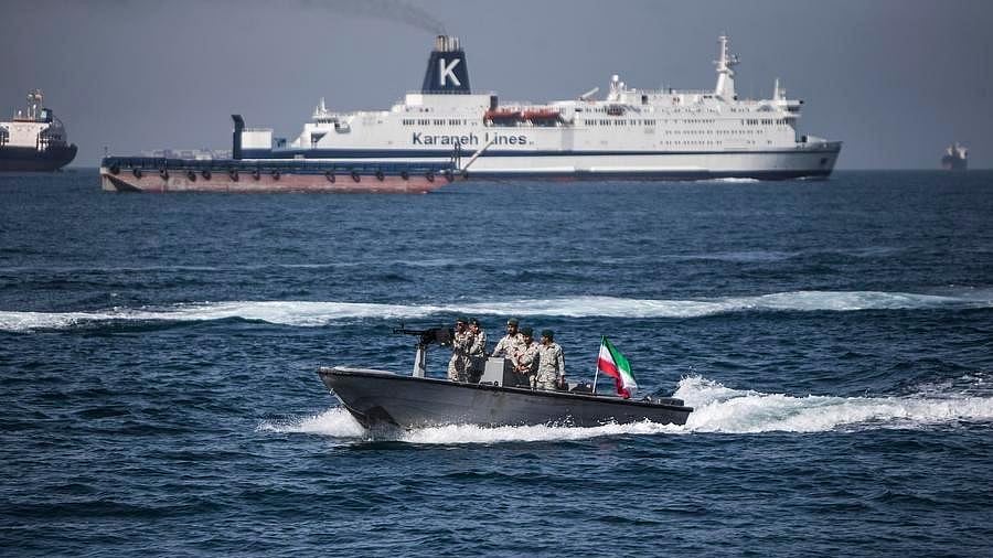 A boat bearing the Iranian flag cruises through the Strait of Hormuz.
