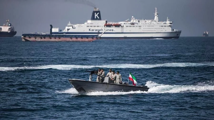 A boat bearing the Iranian flag cruises through the Strait of Hormuz.