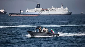 A boat bearing the Iranian flag cruises through the Strait of Hormuz.