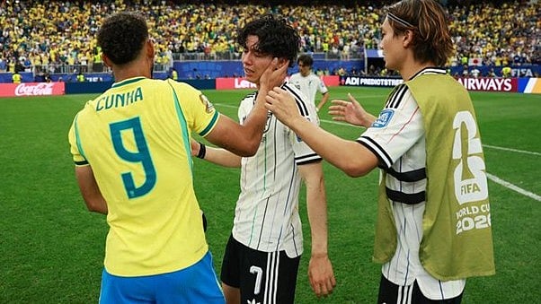 Hard luck: Japan's midfielder Ao Tanaka being consoled by Brazil's Cunha after the game