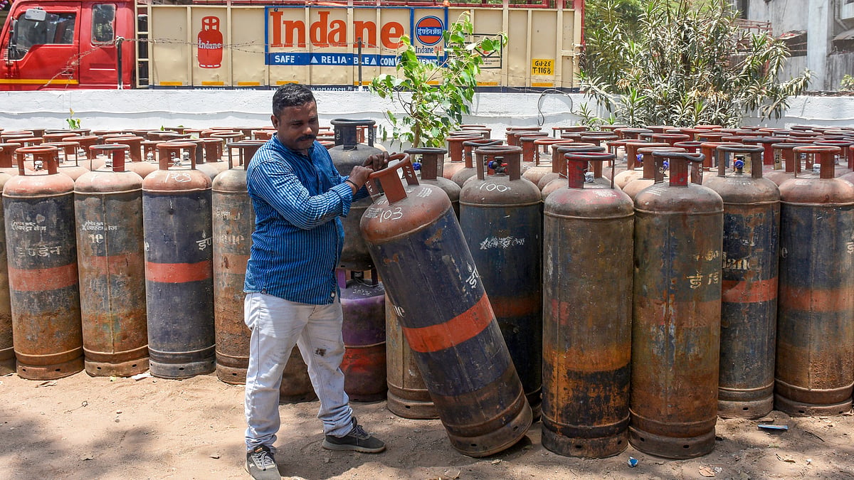 A gas agency worker with an LPG cylinder in Surat.