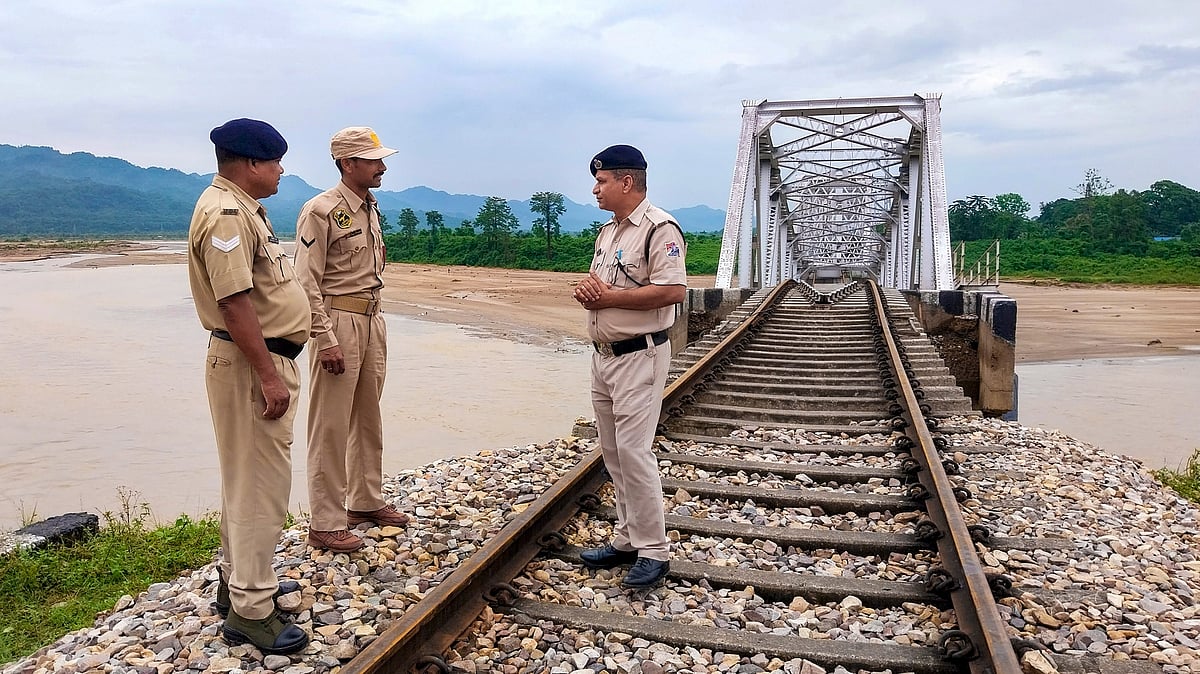 Police personnel stand guard near a railway bridge over the Simen river.