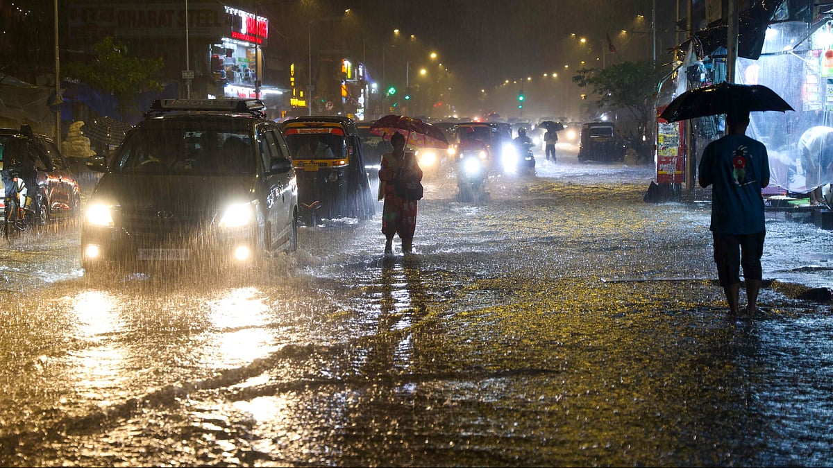 Commuters wade through a waterlogged SV Road in Mumbai's Andheri West.