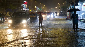 Commuters wade through a waterlogged SV Road in Mumbai's Andheri West.