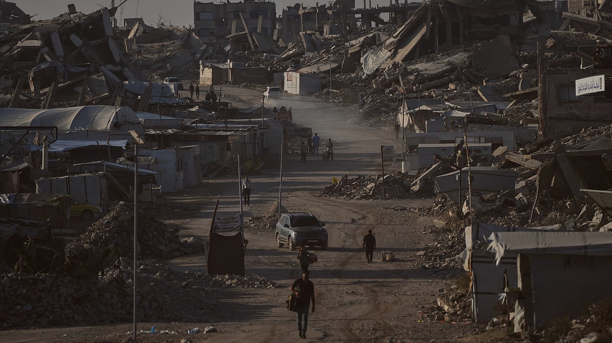 Palestinians walk past buildings destroyed in Israeli strikes in Jabalia, Gaza.