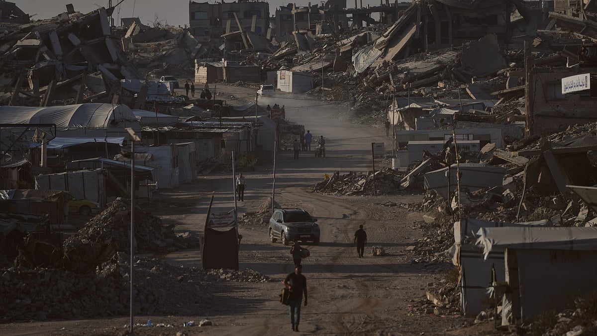 Palestinians walk past buildings destroyed in Israeli strikes in Jabalia, Gaza.
