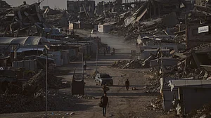 Palestinians walk past buildings destroyed in Israeli strikes in Jabalia, Gaza.