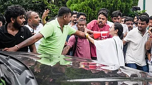 Mamata Banerjee directs party workers as they carry an injured worker (unseen) towards a car