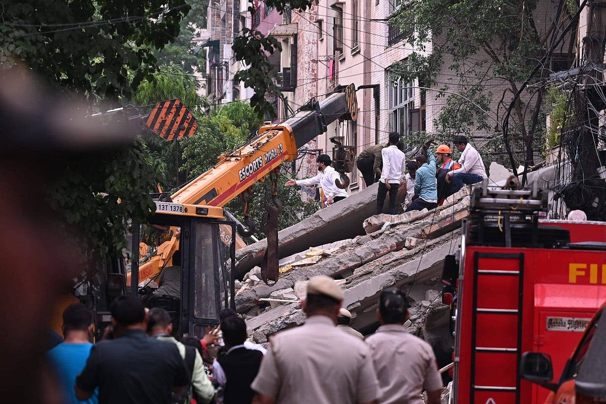 Fire personnel pull three people out of the rubble.