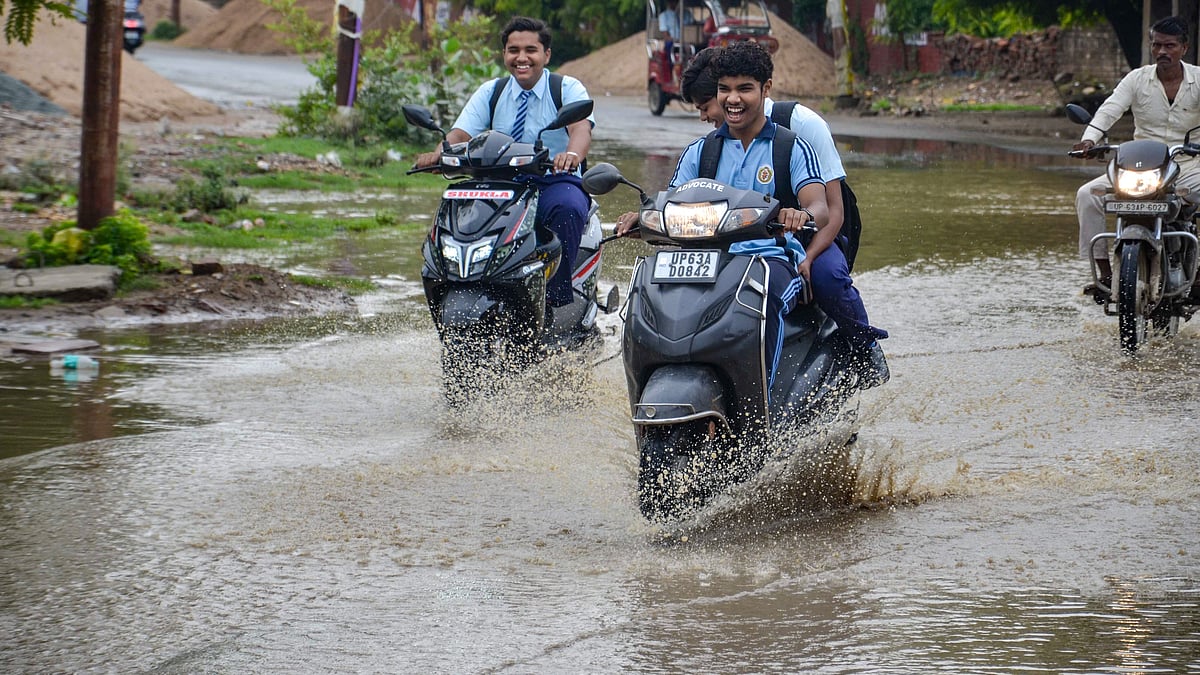 Students drive through a waterlogged road in Mirzapur, Uttar pradesh, on 10 July