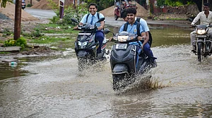 Students drive through a waterlogged road in Mirzapur, Uttar pradesh, on 10 July