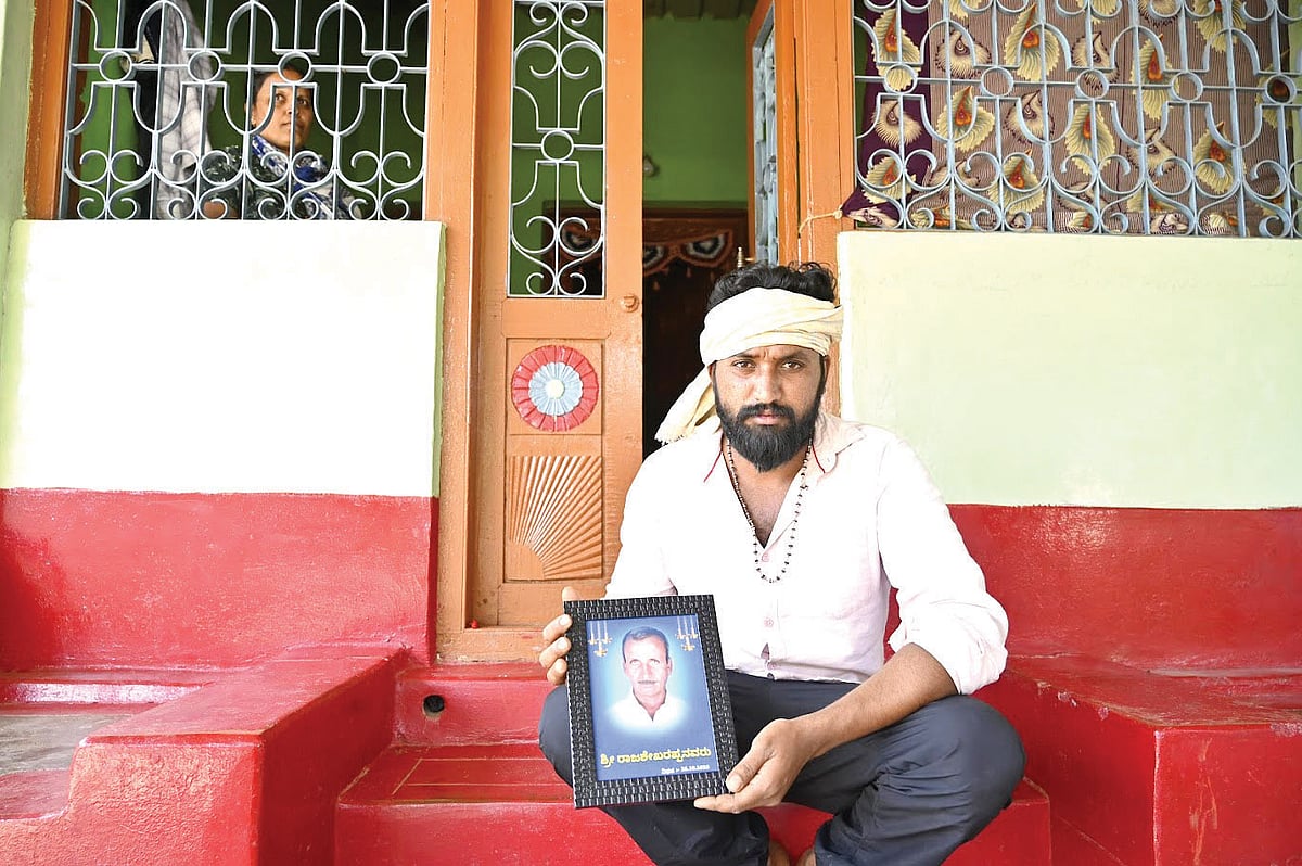 B.R. Sivanand holds a photo of his father Rajasekharappa, who was killed by a tiger