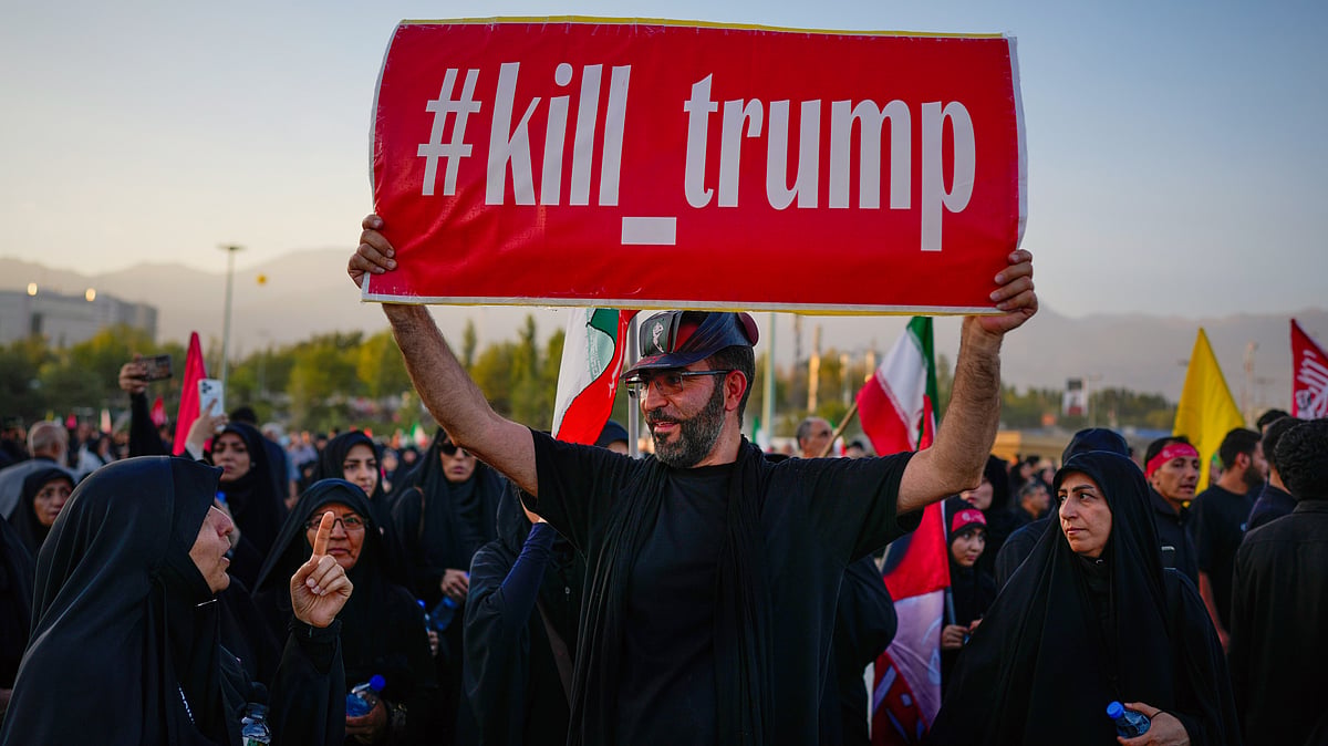 A man holds a sign reading "#kill_trump" as mourners gather for Khamenei's funeral in Tehran, 5 July