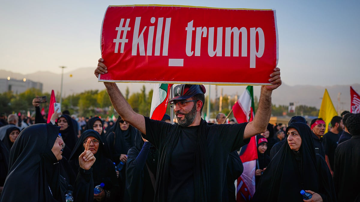 A man holds a sign reading "#kill_trump" as mourners gather for Khamenei's funeral in Tehran, 5 July