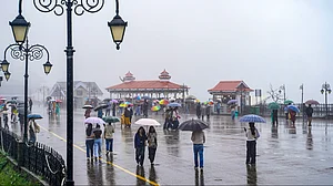 People shield themselves from the rain in Shimla.