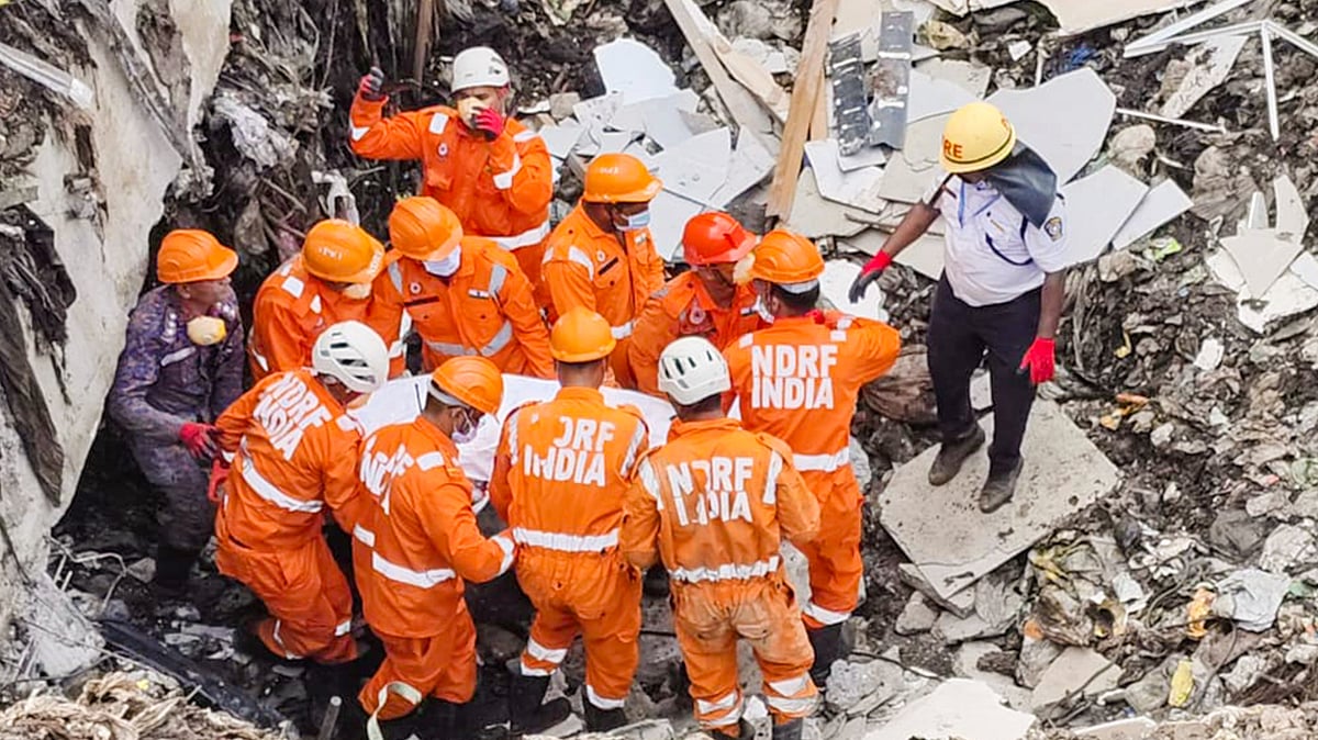 NDRF personnel carry a victim’s remains after Pune waste plant collapse.