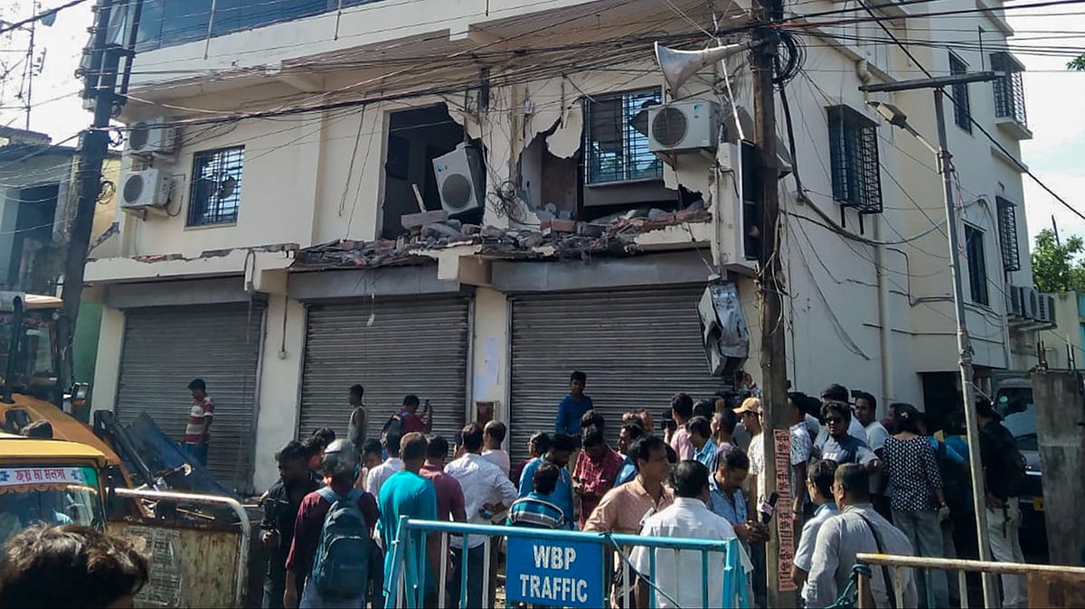 People gather as Abhishek Banerjee’s TMC office is demolished in Amtala.