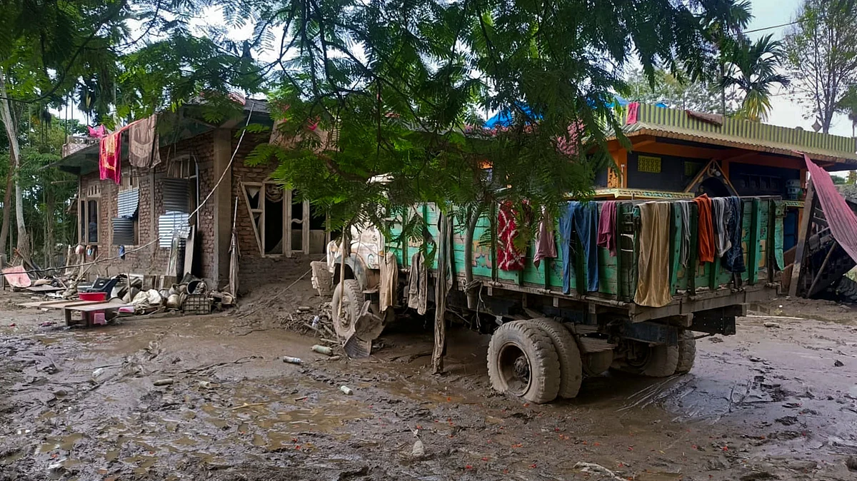 A truck stands amid mud and slush outside flood-affected houses at in Sivasagar, Assam.