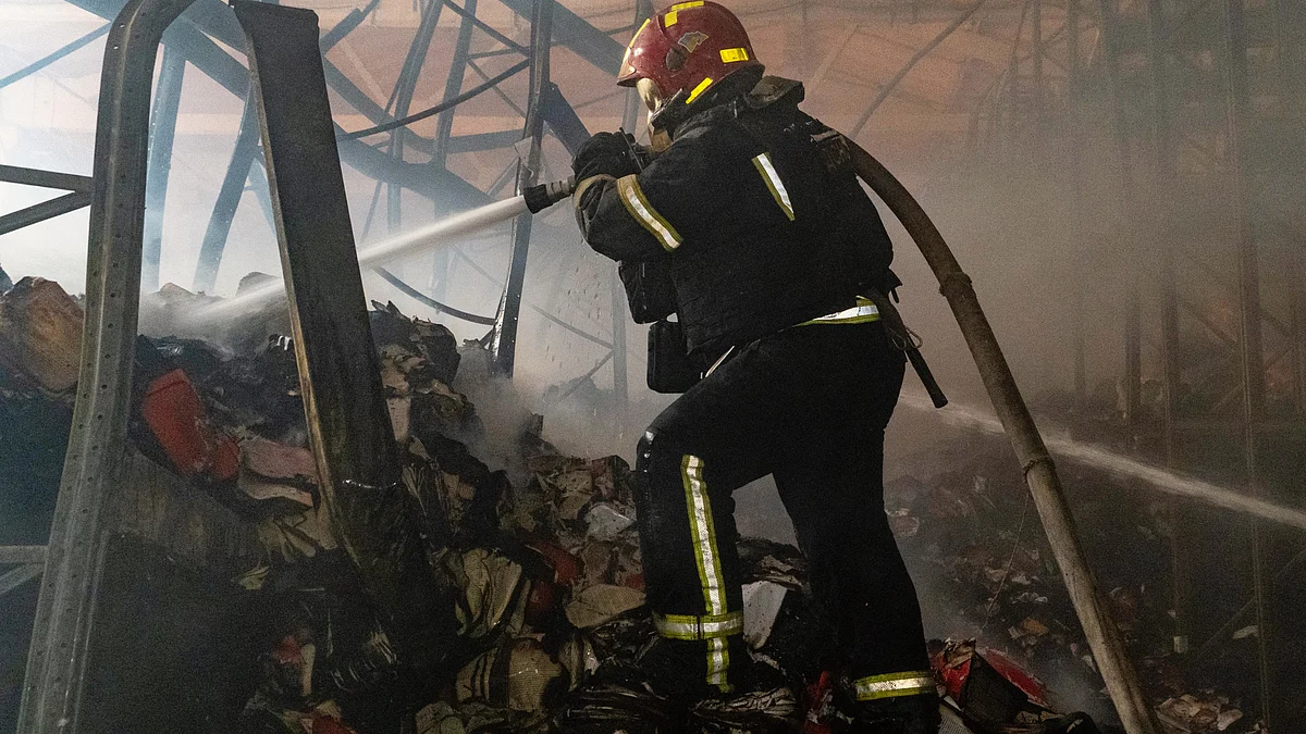A firefighter puts out a fire at a warehouse following Russian drone strikes in Kharkiv, Ukraine,1 Aug