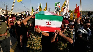 Mourners carry the flag-draped coffin of an Iranian adviser during a funeral procession.