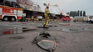 Firefighter reacts near a fragment of a Russian missile after air strikes at a food warehouse near Kyiv.
