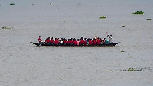 Flooded roads force Morigaon students to take country boats to school.