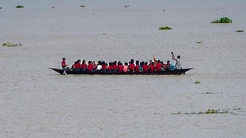 Flooded roads force Morigaon students to take country boats to school.