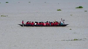 Flooded roads force Morigaon students to take country boats to school.