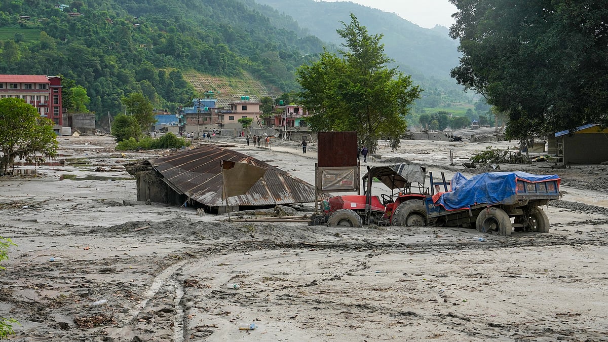 A tractor and structure lie partially submerged in mud in Devighat, Nuwakot.