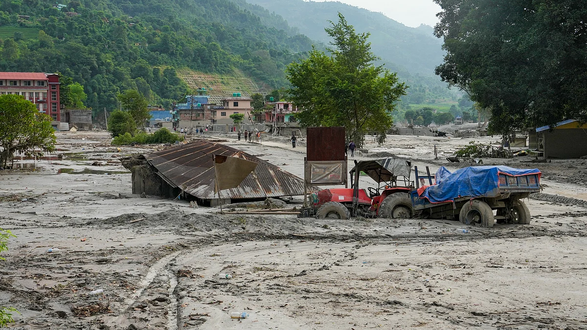 A tractor and structure lie partially submerged in mud in Devighat, Nuwakot.