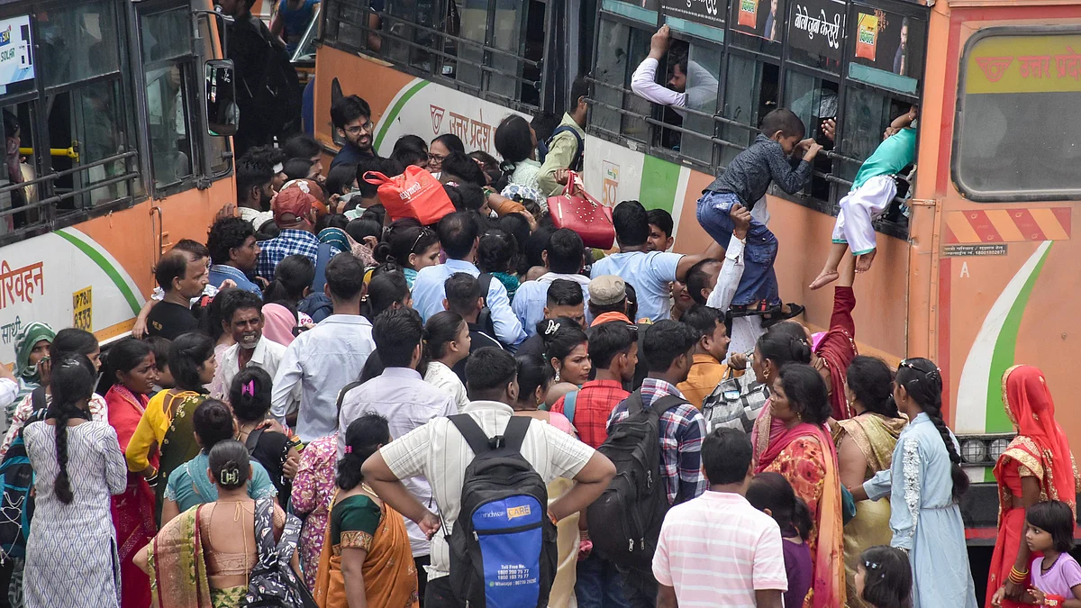 Commuters board a bus through its windows amid heavy rush on Raksha Bandhan in Moradabad.
