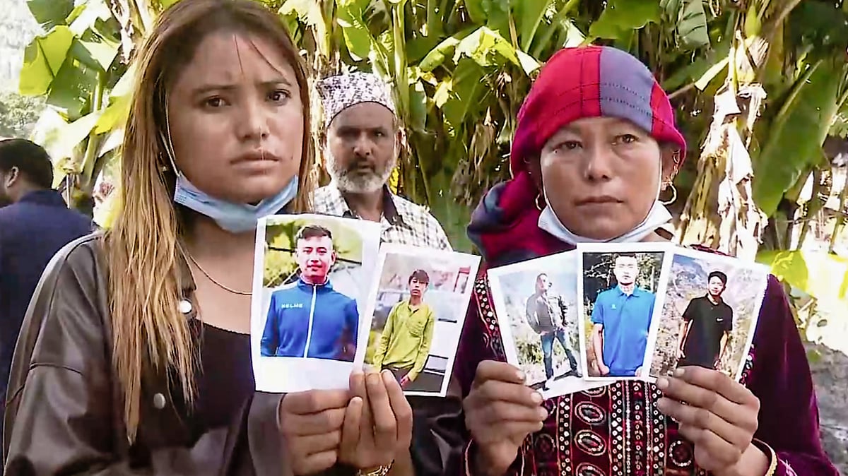 Relatives show photographs of five missing victims amid search operations in Nuwakot district, 30 August