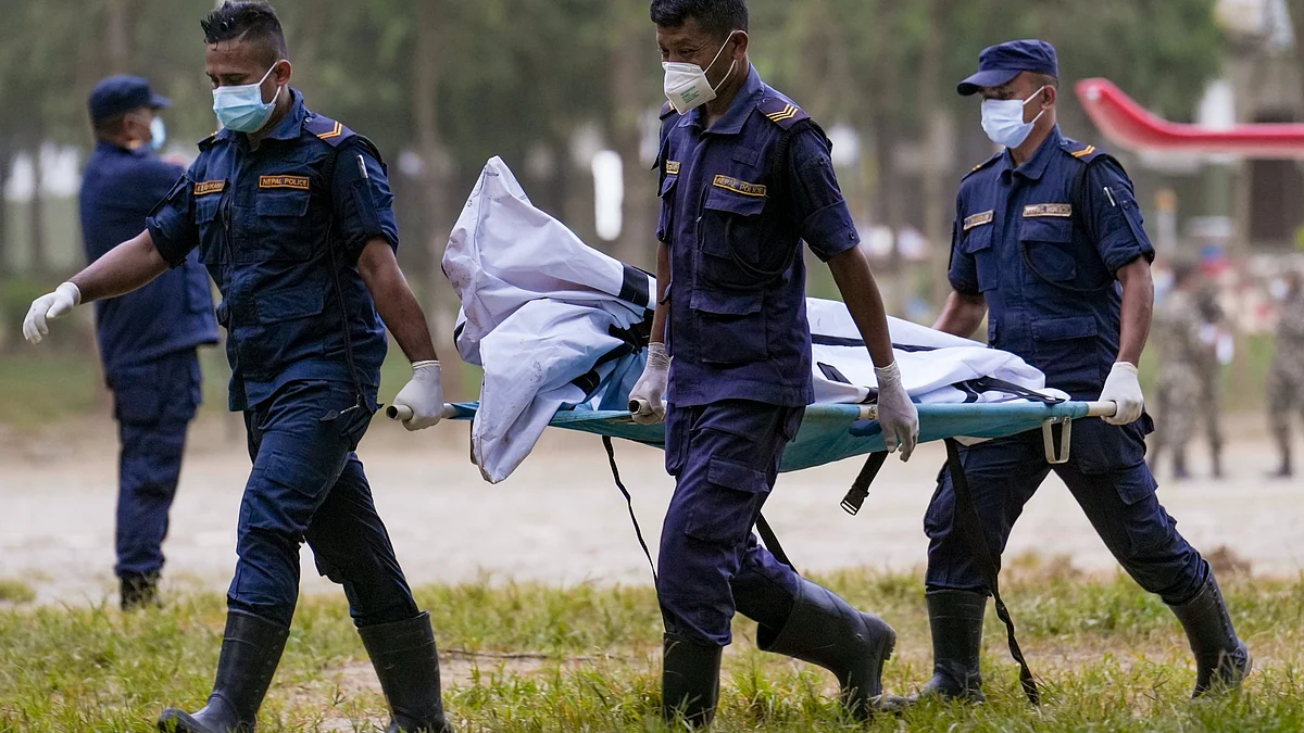 Nepal Police personnel carry the body of a victim at a military base in Nuwakot district.