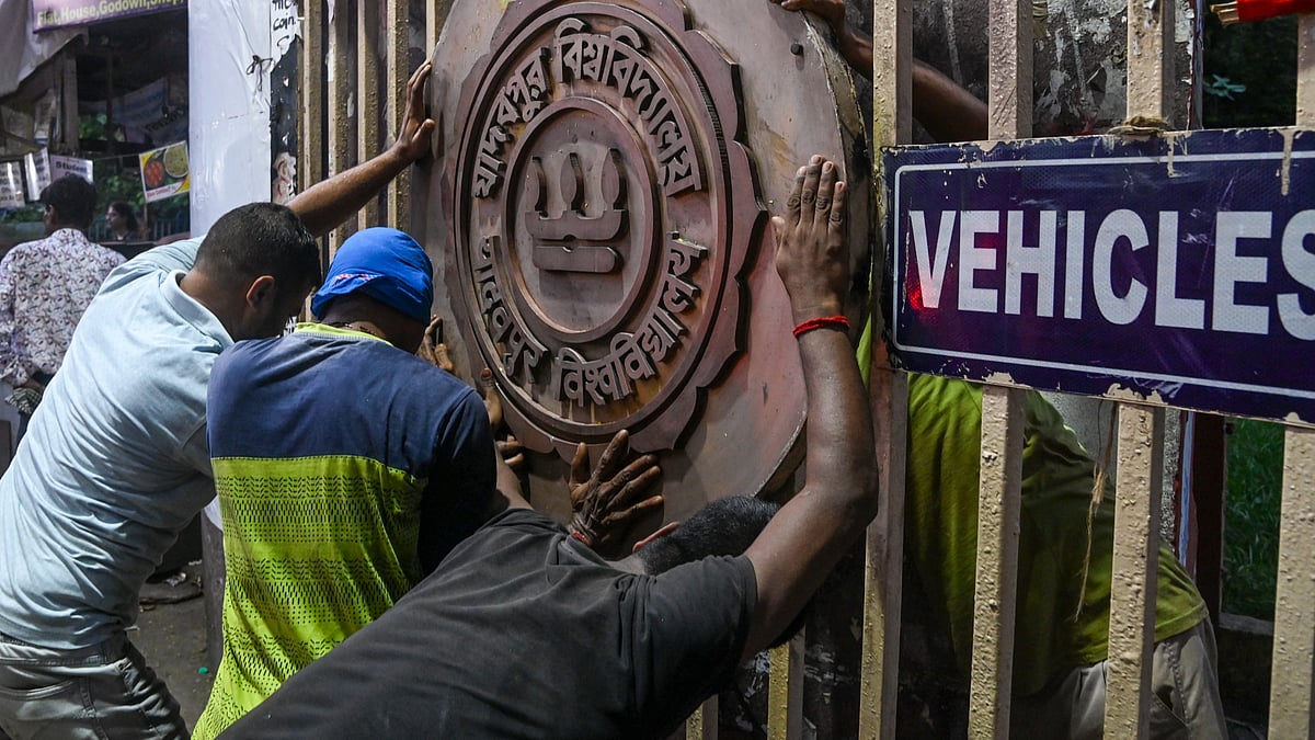 Workers reinstall the Jadavpur University emblem at the main gate.
