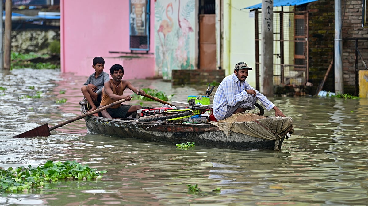 People move to safety by boat as the Ganga rises amid monsoon rains in Prayagraj.
