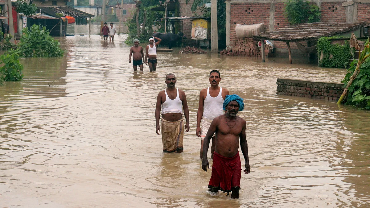 Flood-affected residents wade through floodwaters in Patna.