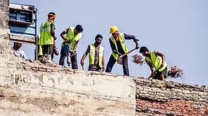 Workers demolish the roof of a building next to the one that collapsed, at Satya Niketan, 10 Sep