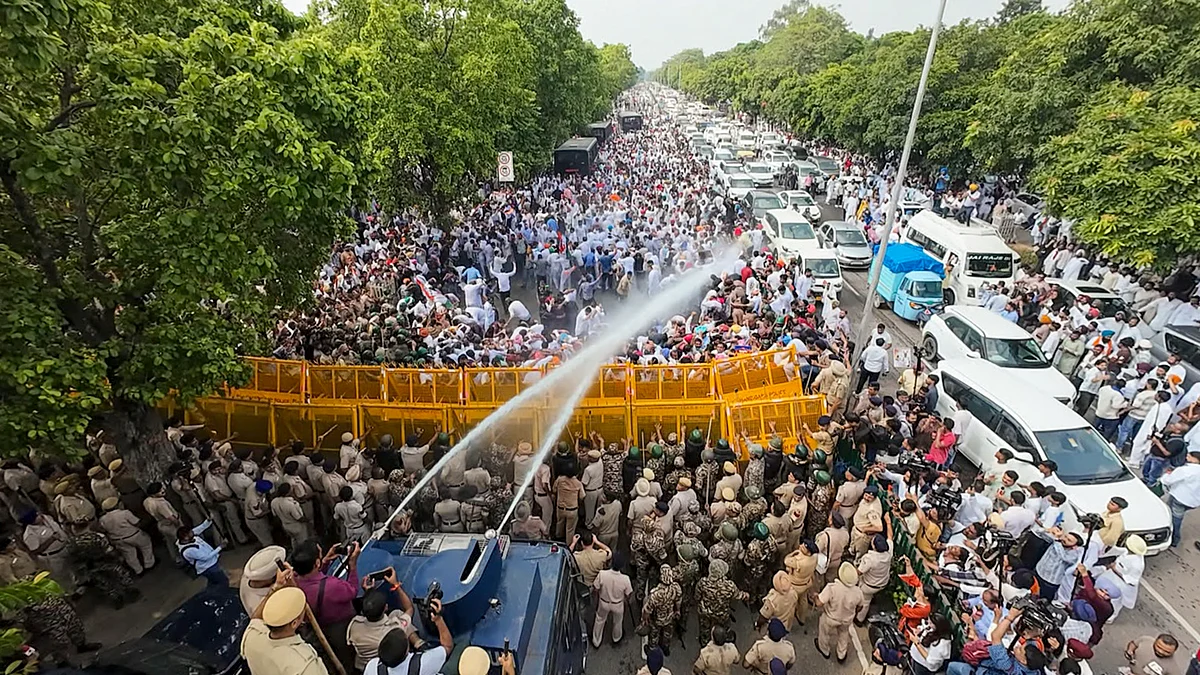 Police personnel use water canons on Congress leaders and workers as they stage a protest.