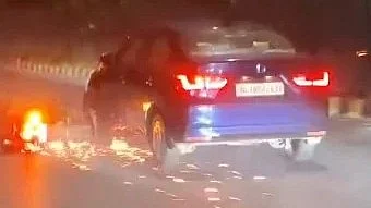 Screengrab from the video showing the motorcycle trapped under the car in Delhi.