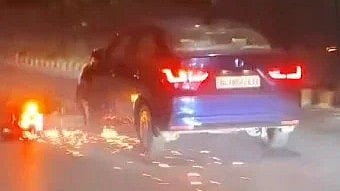 Screengrab from the video showing the motorcycle trapped under the car in Delhi.