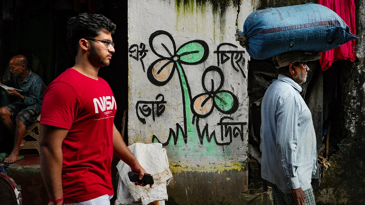 People pass by the old TMC symbol drawn on a wall in Kolkata's Kalighat area, 18 Sep
